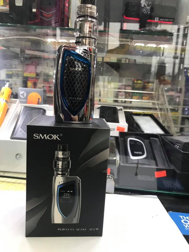 Metallic SMOK vape device with blue and black detailing, displayed on its matching product box in a store.